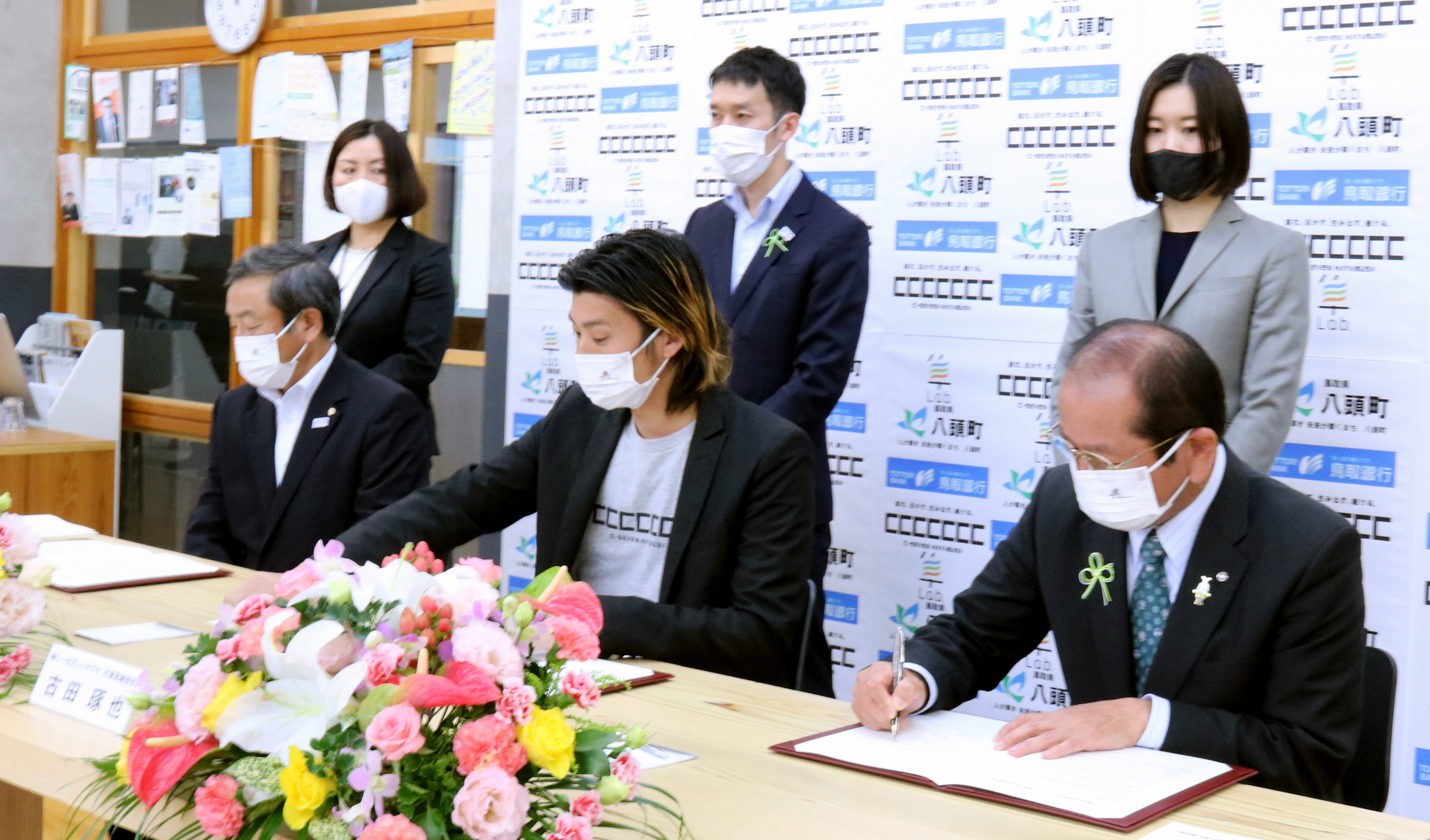 締結式で協定書に署名する平井頭取、古田社長および吉田町長の写真