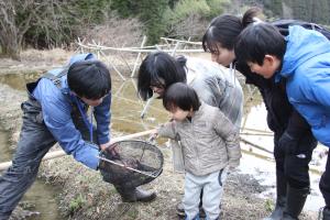 網で捕まえた生き物を観察する参加者