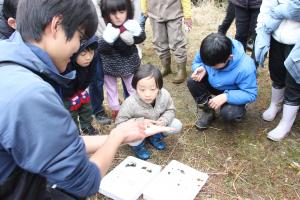網で捕まえた生き物の話を聴く参加者