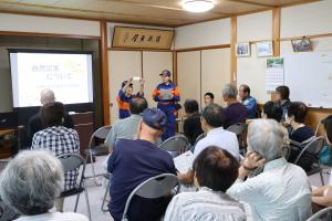 防災学習会で災害時持ち出し品について説明する女性消防隊員