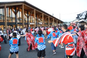 郡家駅前で観客も一緒に鳴子踊りをする様子