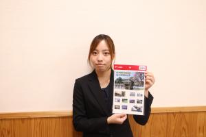 「鳥取県立八頭高等学校　創立百周年記念」フレーム切手を掲げる郵便局職員