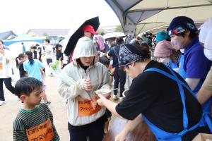 温かいなめこ汁のふるまいをうける参加者