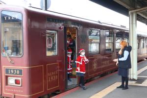 クリスマスの仮装をした参加者が郡家駅で列車から降りる様子