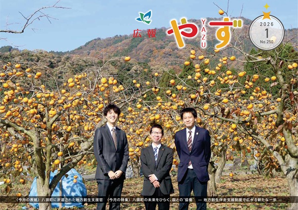 広報やず 令和8年1月号の表紙（花御所柿畑を背景に八頭町へ派遣された地方創生支援官3人の集合写真）