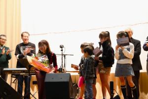 一緒に合唱した子どもから花束をもらう半崎さん