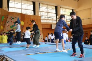 親子が手を繋ぎながらトランポリンでジャンプする様子