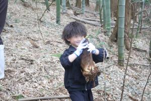 タケノコを手に持ち、笑顔を見せる子ども