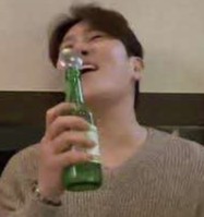 焼酎瓶にスプーンを入れて歌っている人の写真