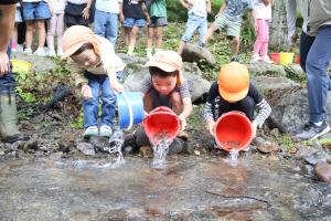 ヤマメの稚魚を川に放流する子どもたち
