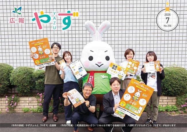 令和8年7月号の表紙（マスコットキャラクターやずぴょんと職員がデジタルポイント「やずP」のチラシやポスターを掲げている写真）