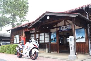 期間限定デザインの駅名板と駅舎と隼バイク