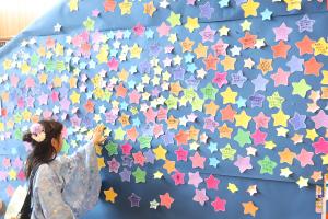 「みんなの願いで天の川を完成させよう」に星形の短冊を貼る子ども