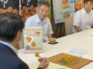 「くずバー」花御所柿味を試食する鳥取県知事