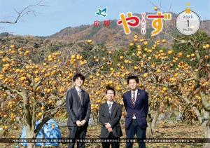 広報やず 令和8年1月号の表紙（花御所柿畑を背景に八頭町へ派遣された地方創生支援官3人の集合写真）