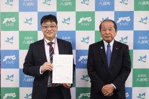 辞令書を手にするキムさん（左）と吉田町長（右）